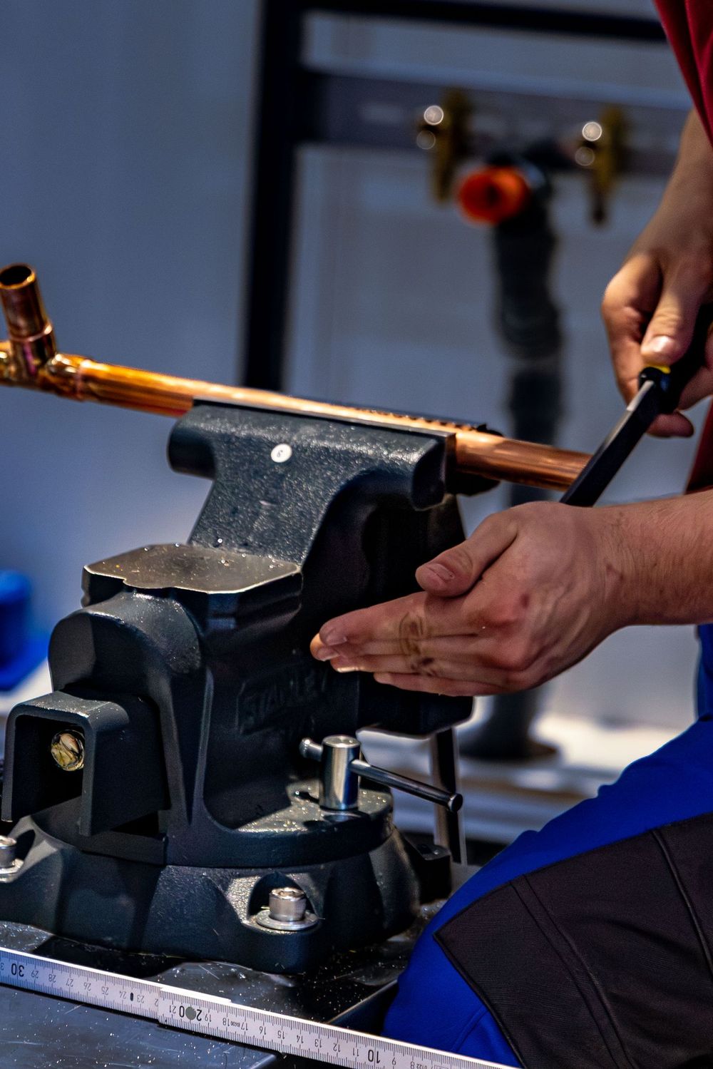 Plumber bending copper pipe in a vise